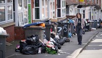 Tempat sampah meluap hingga ke jalanan, menggambarkan krisis pengelolaan sampah yang memburuk di Birmingham. Foto: Getty Images/Christopher Furlong