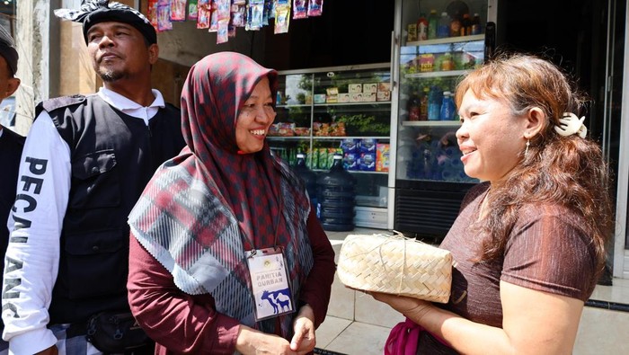 I Gusti Ayu Anjani (58), salah satu warga Hindu di Jalan Padang Griya II. Desa Padangsambian, Denpasar, menerima daging kurban yang dibagikan LDII dalam tradisi Ngejot, Jumat, (6/6/2026). (Aryo Mahendro/detikBali)