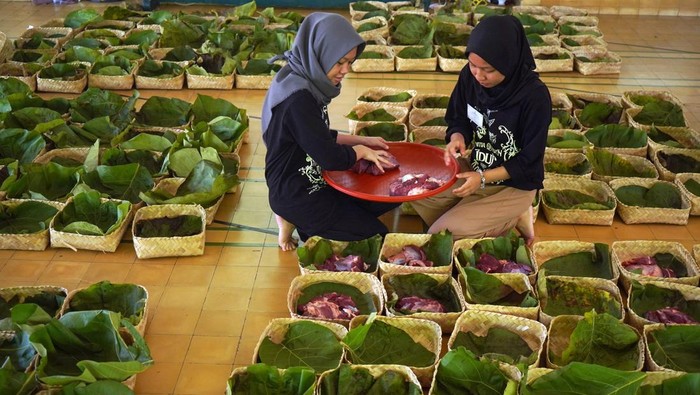 Kurban Bebas Plastik, Warga Jogja Pakai Daun Jati dan Besek Warga membungkus daging kurban dengan daun jati di Masjid Margoyuwono, Kraton, Yogyakarta, Jumat (6/6/2025). Pengurus Masjid Margoyuwono mengemas daging kurban menggunakan daun jati dan besek untuk mendukung program pemerintah DIY terkait permasalahan sampah plastik di Yogyakarta. ANTARA FOTO/Hendra Nurdiyansyah/nym.