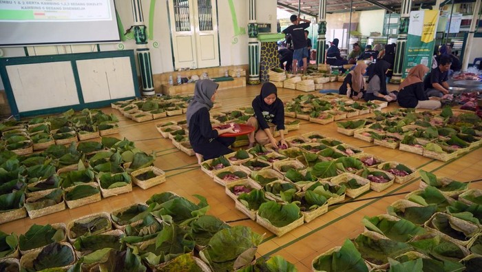 Warga membungkus daging kurban dengan daun jati di Masjid Margoyuwono, Kraton, Yogyakarta, Jumat (6/6/2025). Pengurus Masjid Margoyuwono mengemas daging kurban menggunakan daun jati dan besek untuk mendukung program pemerintah DIY terkait permasalahan sampah plastik di Yogyakarta. ANTARA FOTO/Hendra Nurdiyansyah/nym.