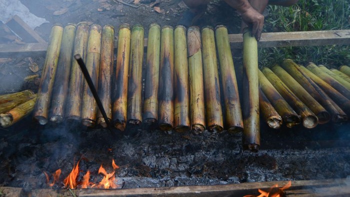 Pekerja membakar lamang (lemang) bambu di Sungai Sapih, Padang, Sumatera Barat, Kamis (5/6/2025). Menjelang Idul Adha 1446 hijriyah, pedagang lamang mengaku pesanannya meningkat dari hari biasa sekitar 20-40 batang per hari menjadi 200-400 batang per hari karena kebutuhan tinggi masyarakat menyediakan makanan terbuat dari beras ketan itu saat hari besar di keluarga mereka sesuai tradisi Minang. ANTARA FOTO/Iggoy el Fitra/bar