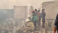 Warga terlihat berkumpul di lokasi kebakaran. Sejumlah petugas Damkar juga masih berupaya memadamkan api. (Taufiq/detikcom)
