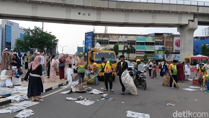Petugas membersihkan sampah sisa salat Idul Adha di Masjid Agung hingga Jembatan Ampera.