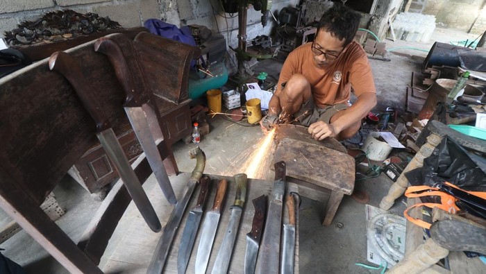 Perajin memotong lempengan mata gerinda bekas sebagai bahan baku pisau di Kelurahan Rejomulyo, Kota Kediri, Jawa Timur, Kamis (5/6/2025). Berbagai model pisau yang terbuat dari lempengan besi per truk dan mata gerinda bekas tersebut mampu diproduksi hingga 4 buah per hari dan dipasarkan melalui media sosial seharga Rp70 ribu hingga Rp4 juta per buah tergantung kualitas bahan dan ukuran.  ANTARA FOTO/Prasetia Fauzani/bar