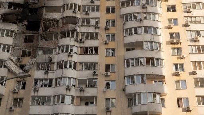 A person looks out from a broken window in a residential building damaged during a Russian air strike in Kyiv on June 6, 2025, amid the Russian invasion of Ukraine. Russia carried out a barrage of drone strikes across Ukraine overnight, killing at least four people and wounding 20 in the capital Kyiv, Ukrainian officials said on June 6. (Photo by Roman PILIPEY / AFP)