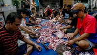 Warga dan panitia kurban gotong royong membagi dan memotong daging kurban sebelum dibagikan kepada yang berhak.