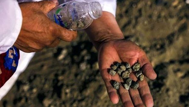 A Muslim pilgrim collects pebbles at Muzdalifah late on June 5, 2025 during the climax of the Hajj pilgrimage, which will be thrown later in the following days during the Stoning of the Devil ritual in Mina. (Photo by HAZEM BADER / AFP)