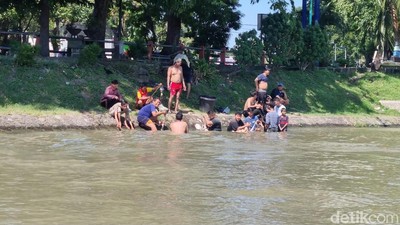 Potret Warga Surabaya Mencuci Rumen di Sungai