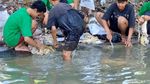 Potret Warga Surabaya Mencuci Rumen di Sungai