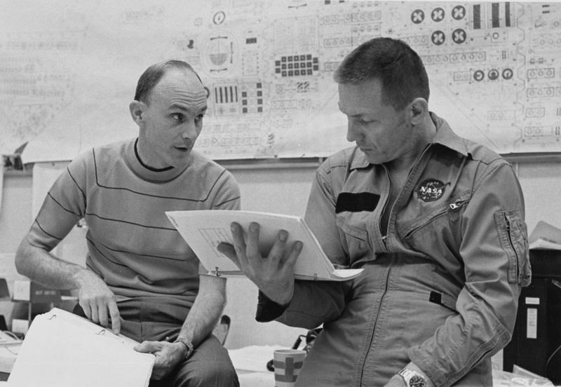 American NASA astronaut Ken Mattingly, wearing a striped t-shirt, as American NASA astronaut Jack Swigert, who wears his NASA flight suit and a Rolex GMT-Master watch, checks the flight plans during preparations ahead of the launch of the Apollo 13 space mission in the Flight Crew Training Building at Kennedy Space Center in Merritt Island, Florida, 9th April 1970. Swigert was the backup crewman to replace Mattingly as Apollo 13 command module pilot following his exposure to Rubella. (Photo by NASA/FPG/Archive Photos/Getty Images)