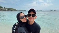 Pose manis Citra dan Resky berlatar pantai berpasir putih dan laut biru.