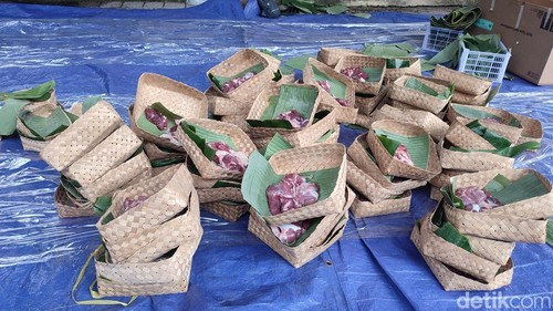 Daging kurban dibagikan dalam kemasan besek.