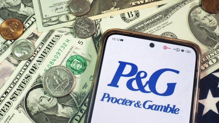 Gara-gara Trump, Raksasa Produk Ritel AS P&G PHK 7.000 Karyawan GERMANY - 2023/09/22: In this photo illustration, The Procter & Gamble Company, P&G logo seen displayed on a smartphone with United States Dollar notes and coins in the background. (Photo Illustration by Igor Golovniov/SOPA Images/LightRocket via Getty Images)