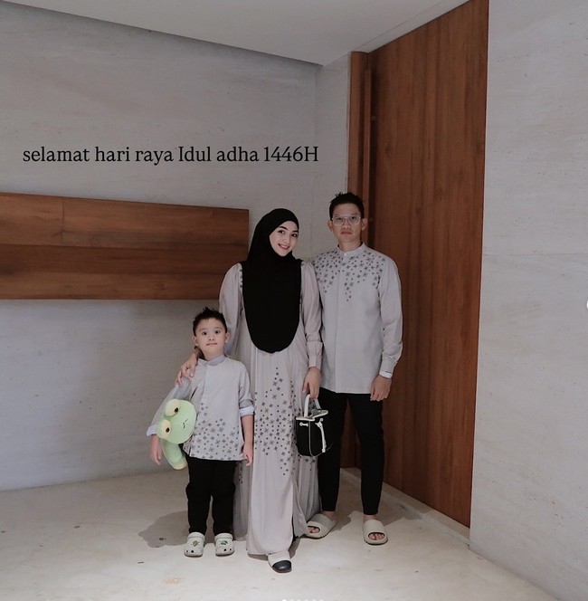Citra Kirana bersama suaminya, Rezky Aditya, dan putra semata wayang mereka juga memilih tampil dengan busana seragam warna abu muda. Busana seragam yang dikenakan Citra dan keluarganya itu memiliki detail motif floral geometris. Foto: Instagram