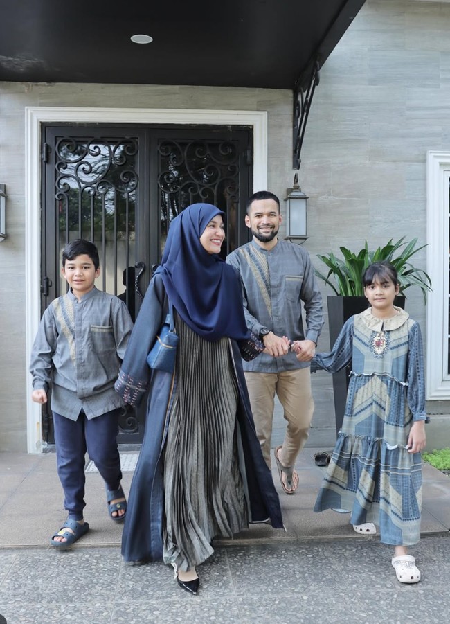 Shireen Sungkar bersama keluarga memilih busana seragam dengan dominasi warna biru, abu-abu, dan coklat. Gamis yang dikenakan Shireen tampak elegan dengan aksen pleats di bagian tengah. Penampilannya itu dipadukan dengan hijab syar’i senada. Foto: Instagram