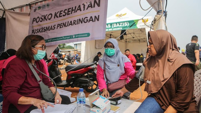 Petugas membawa barang bantuan untuk pengungsi di posko pengungsian, Kapuk Muara, Jakarta, Sabtu (7/6/2025). BPBD Provinsi DKI Jakarta mencatat jumlah pengungsi terdampak kebakaran di Kampung Rawa Indah, Kapuk Muara mencapai sekitar 400 kepala keluarga atau sekitar 2.000 jiwa, dan bantuan logistik, tenda, pemeriksaan kesehatan serta pakaian telah didistribusikan. ANTARA FOTO/Asprilla Dwi Adha/rwa.