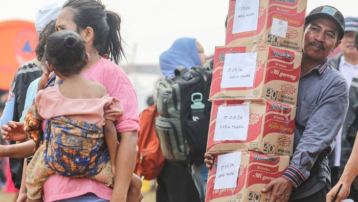 Petugas membawa barang bantuan untuk pengungsi di posko pengungsian, Kapuk Muara, Jakarta, Sabtu (7/6/2025). BPBD Provinsi DKI Jakarta mencatat jumlah pengungsi terdampak kebakaran di Kampung Rawa Indah, Kapuk Muara mencapai sekitar 400 kepala keluarga atau sekitar 2.000 jiwa, dan bantuan logistik, tenda, pemeriksaan kesehatan serta pakaian telah didistribusikan. ANTARA FOTO/Asprilla Dwi Adha/rwa.