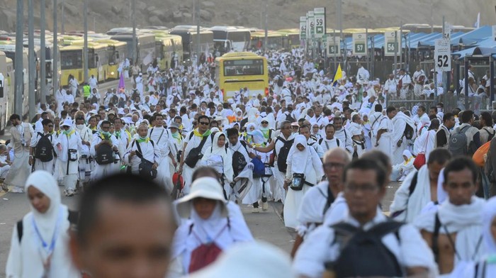 Jamaah haji dari berbagai negara termasuk Indonesia berjalan kaki di samping deretan bus yang tidak bisa bergerak karena terjebak kemacetan di Muzdalifah, Makkah, Arab Saudi, Jumat (6/6/2025). Sebagian jamaah haji memilih berjalan kaki dari Muzdalifah menuju Mina karena kepadatan lalu lintas yang sempat menghambat kelancaran operasional bus terutama penjemputan. ANTARA FOTO/Andika Wahyu/foc.