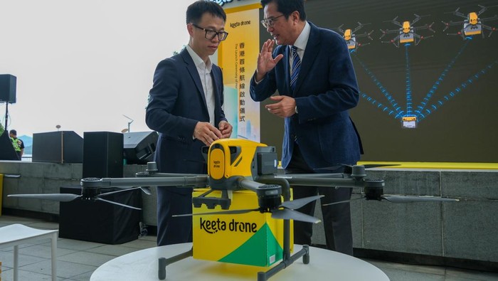 Penampakan Perdana Drone Pengantar Pesanan Makanan HONG KONG, CHINA - JUNE 06: Meituan vice president Mao Yinian (L) communicates with Hong Kong's Secretary for Development Michael Wong Wai-lun as Meituan Keeta Drone officially launches its first delivery route on June 6, 2025 in Hong Kong, China. The first delivery route starts from Hong Kong Science Park in Sha Tin and ends at Ma On Shan Promenade, which costs about 5 minutes. (Photo by Chen Yongnuo/China News Service/VCG via Getty Images)