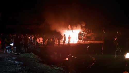 Kobaran api menyala ketika warga membakar alat berat dan gazebo di lokasi tambang galian C, Lombok Timur, NTB, Jumat (6/6/2025).