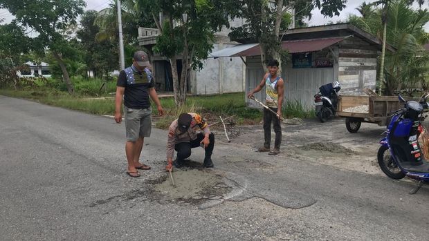 Bhabinkamtibmas di Kecamatan Tebing Tinggi, Kepulauan Meranti, Riau, menutup jalan rusak dengan semen untuk mencegah korban.