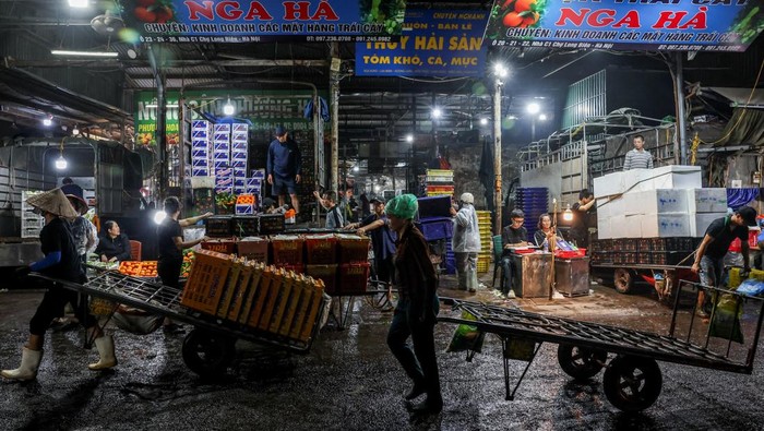 Detak Ekonomi Pasar Grosir Legendaris Hanoi A merchant carries goods that she bought at Long Bien Market, one of the largest wholesale markets in Hanoi, in Hanoi, Vietnam, May 28, 2025. REUTERS/Chalinee Thirasupa