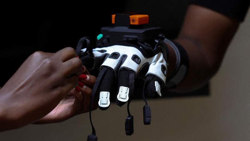 Charity Eshinyali, 21, a deaf sign language worker, gestures as a motion capture suit calibrates her movements on a screen at Signvrse that developed AI-powered sign language translation technology to bridge communication gaps for deaf people, in Nairobi, Kenya April 30, 2025. REUTERS/Monicah Mwangi