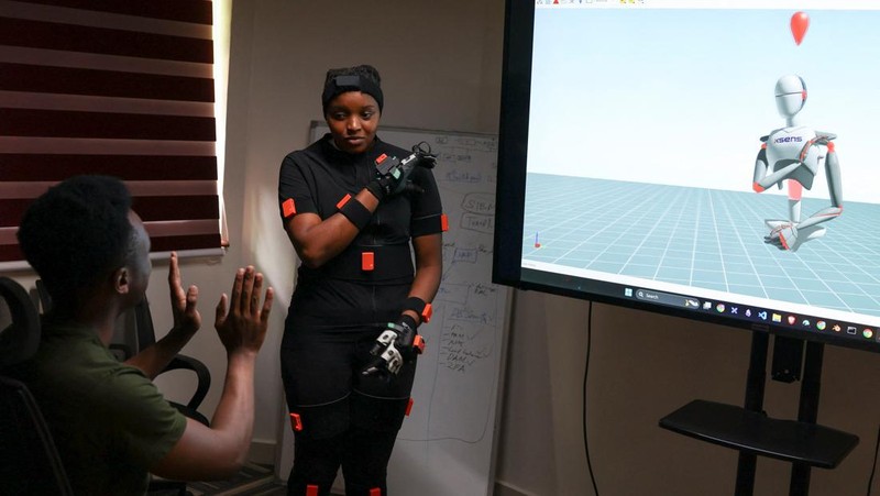 Charity Eshinyali, 21, a deaf sign language worker, gestures as a motion capture suit calibrates her movements on a screen at Signvrse that developed AI-powered sign language translation technology to bridge communication gaps for deaf people, in Nairobi, Kenya April 30, 2025. REUTERS/Monicah Mwangi