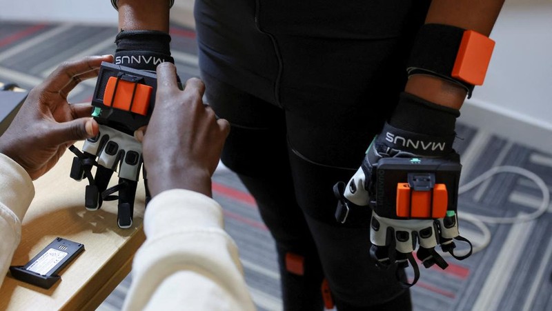 Charity Eshinyali, 21, a deaf sign language worker, gestures as a motion capture suit calibrates her movements on a screen at Signvrse that developed AI-powered sign language translation technology to bridge communication gaps for deaf people, in Nairobi, Kenya April 30, 2025. REUTERS/Monicah Mwangi