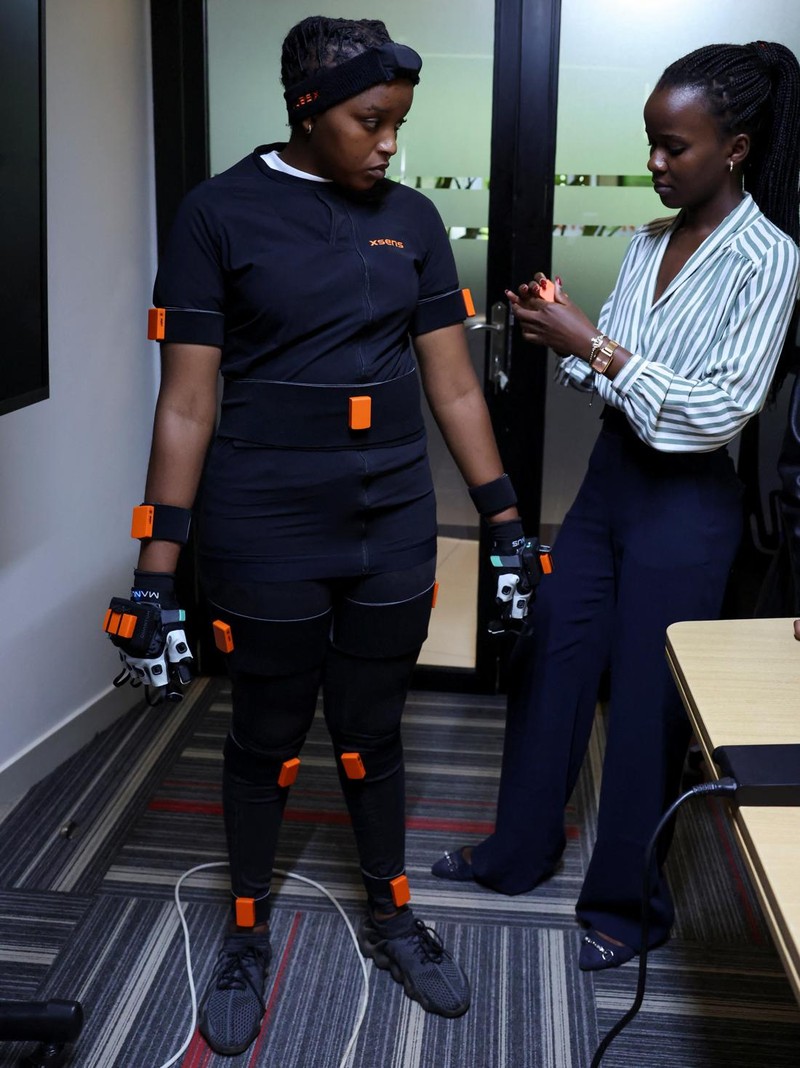 Charity Eshinyali, 21, a deaf sign language worker, gestures as a motion capture suit calibrates her movements on a screen at Signvrse that developed AI-powered sign language translation technology to bridge communication gaps for deaf people, in Nairobi, Kenya April 30, 2025. REUTERS/Monicah Mwangi