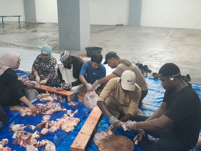 Mahasiswa asing UB ikut membantu membagikan daging kurban
