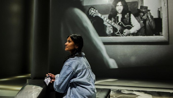 Guests take a picture during Rolling Stone presents: AMPLIFIED exhibition at ARTECHOUSE in New York City, U.S. May 29, 2025. REUTERS/Jeenah Moon.