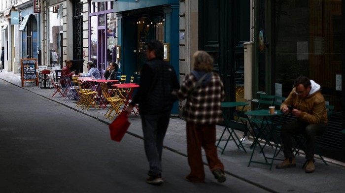 Menikmati Romansa Musim Semi di Paris People walk past cafe terraces in a street in Paris, France, May 6, 2025. REUTERS/Sarah Meyssonnier