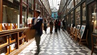Orang-orang berjalan di lorong Jouffroy yang tertutup di Paris. Foto: REUTERS/Abdul Saboor