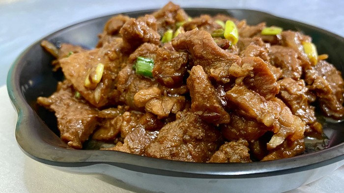 Beef Teriyaki on Plastic Skillet Plate with green onion on top.