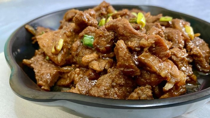 Beef Teriyaki on Plastic Skillet Plate with green onion on top.