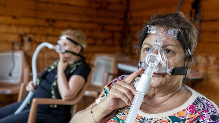 Senay Ilhan, Tenzile Kilic and Ulku Ozman breath in air from beehives through ventilators in hopes of recovering from ailments at a facility owned by beekeeper Huseyin Ceylan in Karaburun, located in Turkey's Aegean coastal province of Izmir, Turkey, May 22, 2025. REUTERS/Umit Bektas