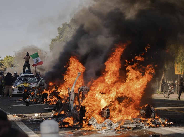 Los Angeles, CA, Sunday, June 8, 2025 - People take turns vandalizing a Waymo taxi as protesters take to the streets to protest ICE immigration raids throughout the city.  (Robert Gauthier/Los Angeles Times via Getty Images)