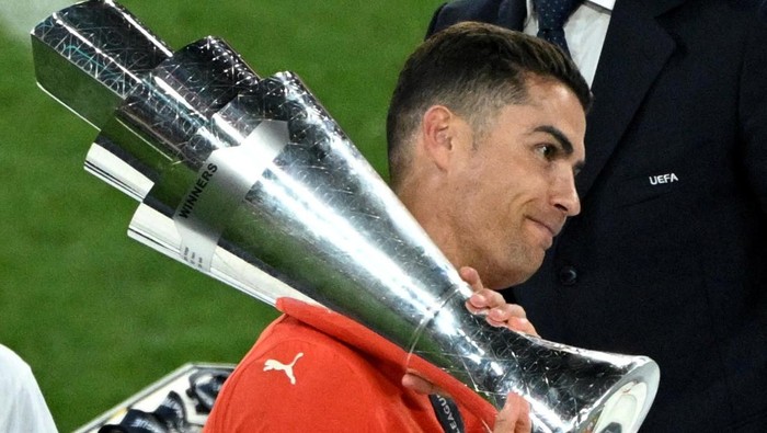 Soccer Football - Nations League - Final - Portugal v Spain - Allianz Arena, Munich, Germany - June 9, 2025 Portugals Cristiano Ronaldo collects the trophy from UEFA president Aleksander Ceferin after winning the Nations League REUTERS/Annegret Hilse     TPX IMAGES OF THE DAY