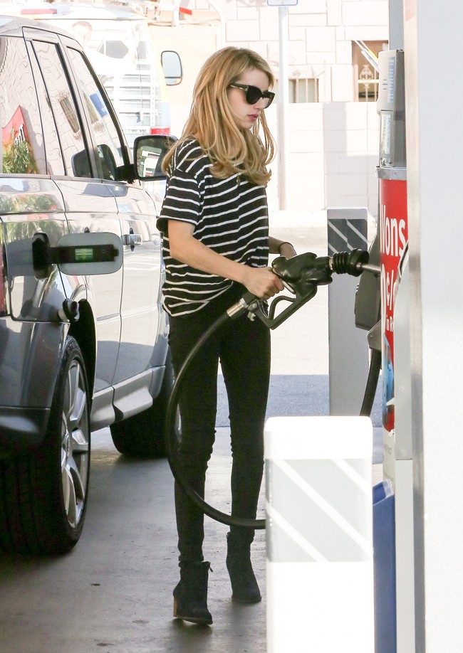 Kaus longgar dan slim jeans menjadi andalan Emma Roberts saat dalam sebuah kesempatan mampir ke pompa bensin untuk mengisi bensin mobil Range Rover yang disetirinya. (Foto: Bauer-Griffin/GC Images)