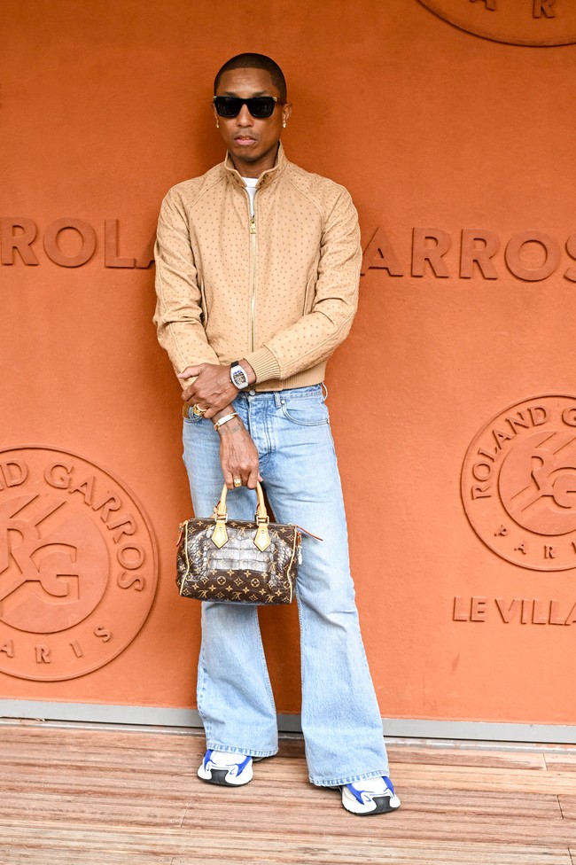 Para selebriti pria pun tak kalah stylish saat menyaksikan final satu-satunya grand slam tenis lapangan tanah liat itu. Musisi sekaligus direktur kreatif busana pria Louis Vuitton, Pharrell Williams, datang dengan jaket bomber coklat yang senada dengan lapangan Roland Garros. Atasan tersebut dipadu dengan jeans berpotongan cut-bray dan aksesori berupa kacamata, jam fancy Richard Mille, dan tentu saja Speedy Bag, tas signature keluaran LV. (Foto: Stephane Cardinale/Corbis via Getty Images)