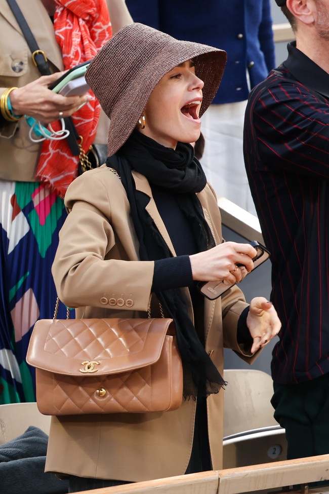 Aktris Lily Collins pun tak melewatkan laga yang berakhir dengan kemenangan Alcaraz. Kombinasi palet coklat, seperti mocha mousse yang menjadi color of the year 2025 versi Pantone, menjadi andalan Bintang Emily in Paris itu. Tanpa terkecuali tas ikonis Flap Bag Chanel. (Foto: Pierre Suu/WireImage)