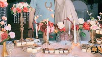 Irish Bella tampak bahagia berpose dengan sang suami. Di hadapan mereka terdapat aneka kue cantik dengan hiasan bunga yang menarik. Foto: Instagram @_irishbella