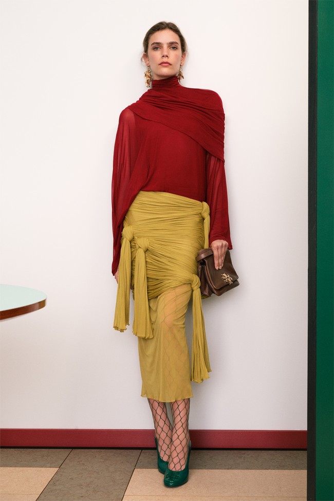 Detail khas seperti kerah yang bisa diatur dan blus yang membalut bahu seperti syal memperkuat semangat dekonstruksi prep. Inspirasi dari workwear vintage Jepang tampak dalam jaket lapangan yang diperkecil dan detail fungsional seperti jahitan kontras serta panel lutut yang diperkuat. (Foto: Dok. Tory Burch)