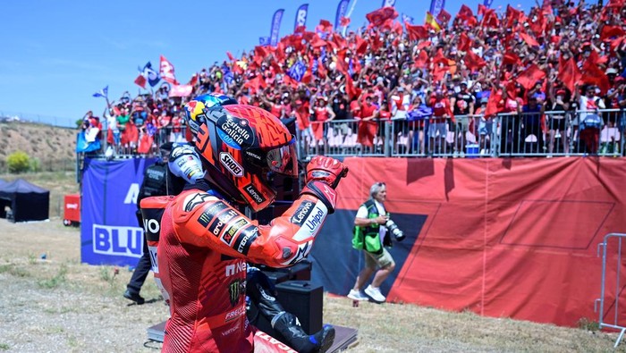 Winner team Ducati Lenovo Teams Marc Marquez and his brother team Gresini Racing MotoGPs Alex Marquez celebrate with fans after the MotoGP Aragon Grand Prix race at the Motorland circuit in Alcaniz, northeastern Spain, on June 8, 2025. (Photo by JOSE JORDAN / AFP)