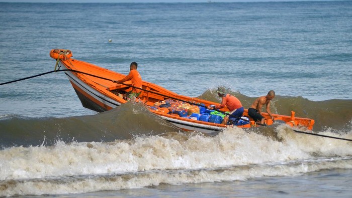 Nelayan mengendalikan perahu bermuatan BBM untuk kapal bagan menerjang ombak di pantai Pasia Nan Tigo Padang, Sumatera Barat, Senin (9/6/2025). Menurut sebagian besar nelayan pemasok ikan di daerah itu mereka sudah kembali melaut pascalibur Idul Adha meskipun kondisi gelombang laut masih tinggi. ANTARA FOTO/Iggoy el Fitra/tom.