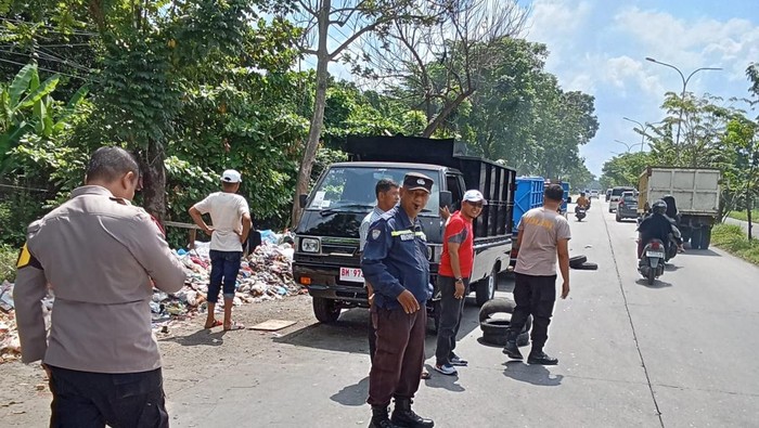Para Bhabinkamtibmas dan Lurah Sidomulya Barat, Pekanbaru bergotong-royong membersihkan sampah di Jalan Soekarno-Hatta, Minggu (8/6/2025).