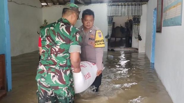 Polisi dan TNI bantu warga terdampak banjir di Mojokerto mengevakuasi barang-barang berharga.