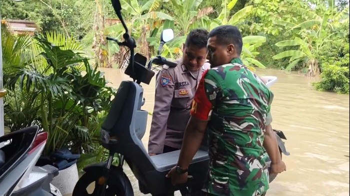 Polisi dan TNI bantu warga terdampak banjir di Mojokerto mengevakuasi barang-barang berharga.