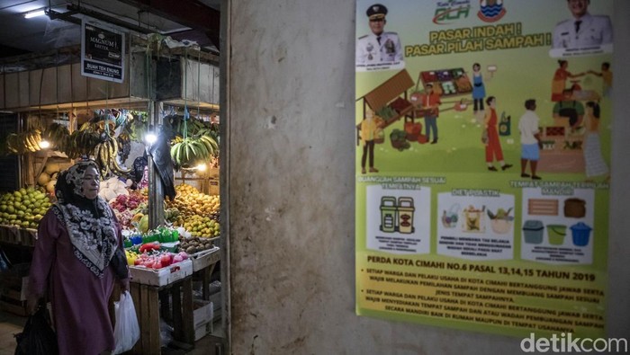 Rencana pembatasan penggunaan plastik sekali pakai di Cimahi Warga membawa belanjaan menggunakan kantong plastik berjalan di dekat poster imbauan pilah sampah di Pasar Atas Baru, Kota Cimahi, Jawa Barat, Senin (9/6/2025). Pemerintah Kota Cimahi berencana menerapkan aturan pembatasan penggunaan plastik sekali pakai yang akan diterapkan paling lambat pada awal tahun 2026 dengan sasaran awal toko modern dan pasar tradisional guna mengurangi penggunaan plastik sekali pakai yang menjadi salah satu penyumbang sampah terbanyak di kota itu dengan persentase mencapai 22 persen. ANTARA FOTO/Abdan Syakura/bar
